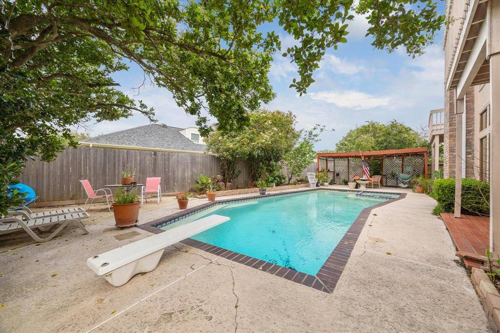 THE POOL OFFERS A DIVING BOARD AT ONE END AND HOT TUB AT THE OTHER.