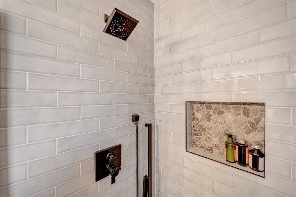 Large primary bathroom shower with tasteful stone niche.