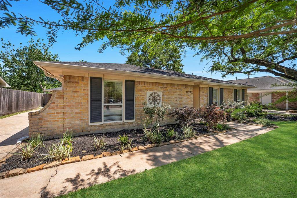 Low maintenance stone-lined garden beds along the walkway leading to the front door of the home.