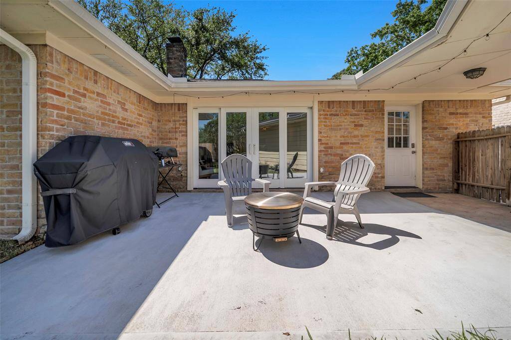 The spacious back patio offers a relaxing atmosphere with plenty of privacy. The double doors on the left lead into the family room while the door on the right leads into the utility room off of the breakfast room.