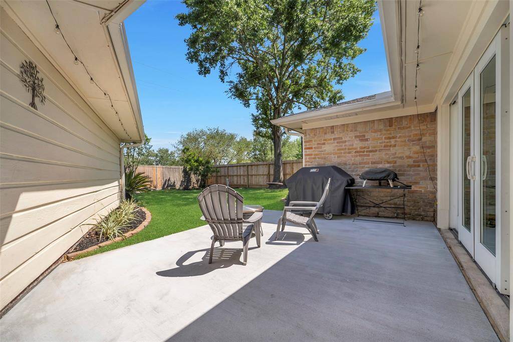The patio looks out onto the luscious green, fully fenced backyard space. This is the perfect area for al-fresco dining and kicking back all year-round!