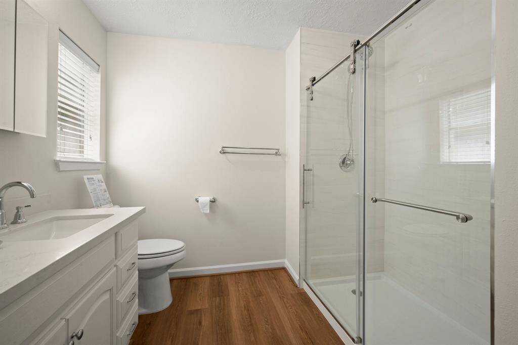 The upgraded primary bath includes a sleek frameless glass shower, new fixtures,