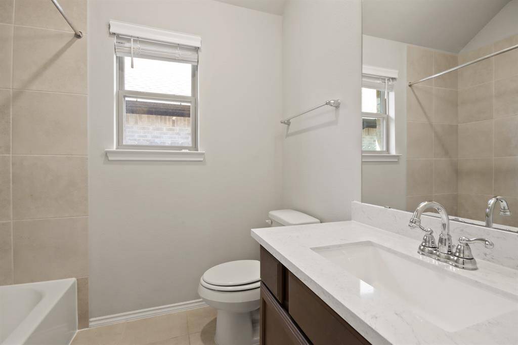 Second bathroom with single vanity sink and tub/shower combo.