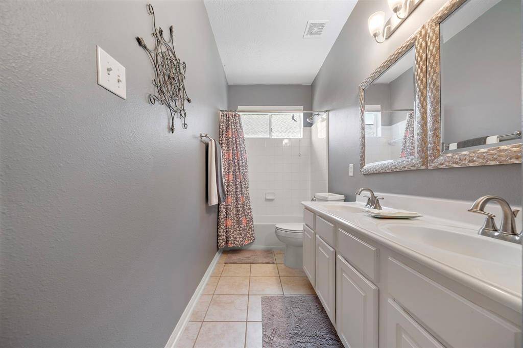 The secondary bathroom offers two sinks and great storage.