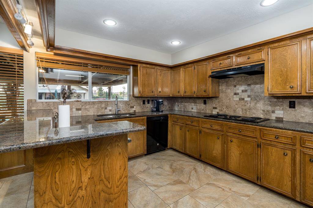 Granite kitchen with 5 burner stove, recent dishwasher and real wood cabinets.