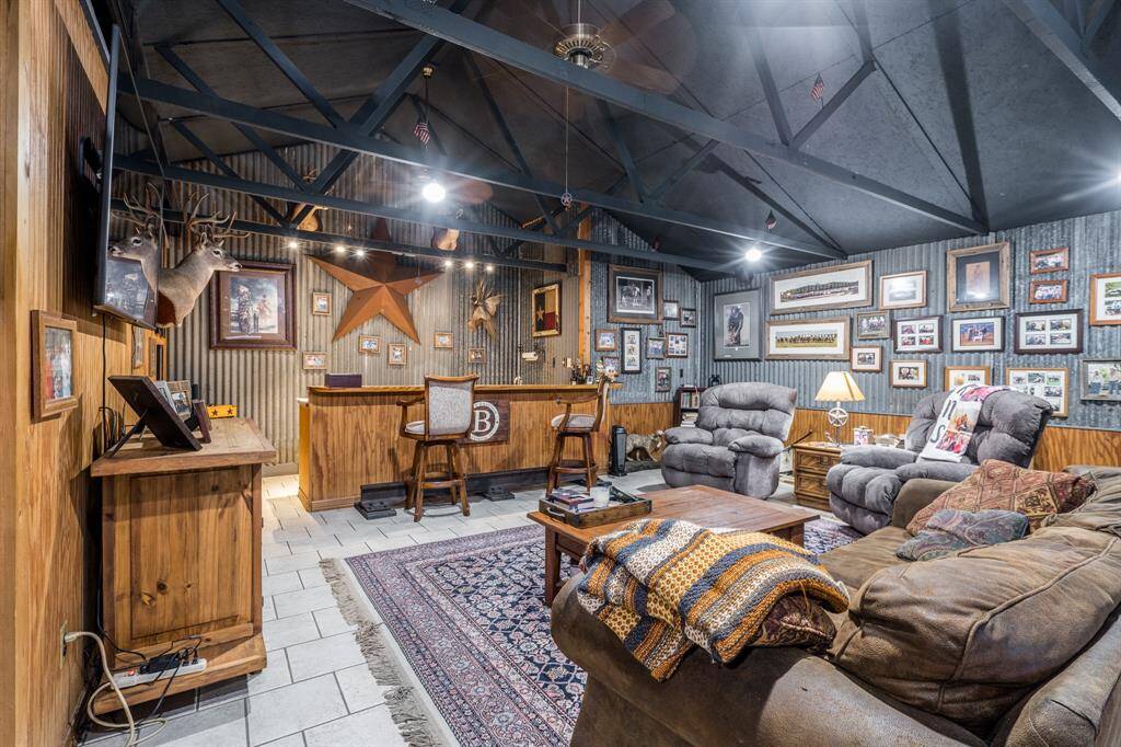 Features include high ceiling, corrugated tin and wood paneled walls, tile flooring and custom lighting.