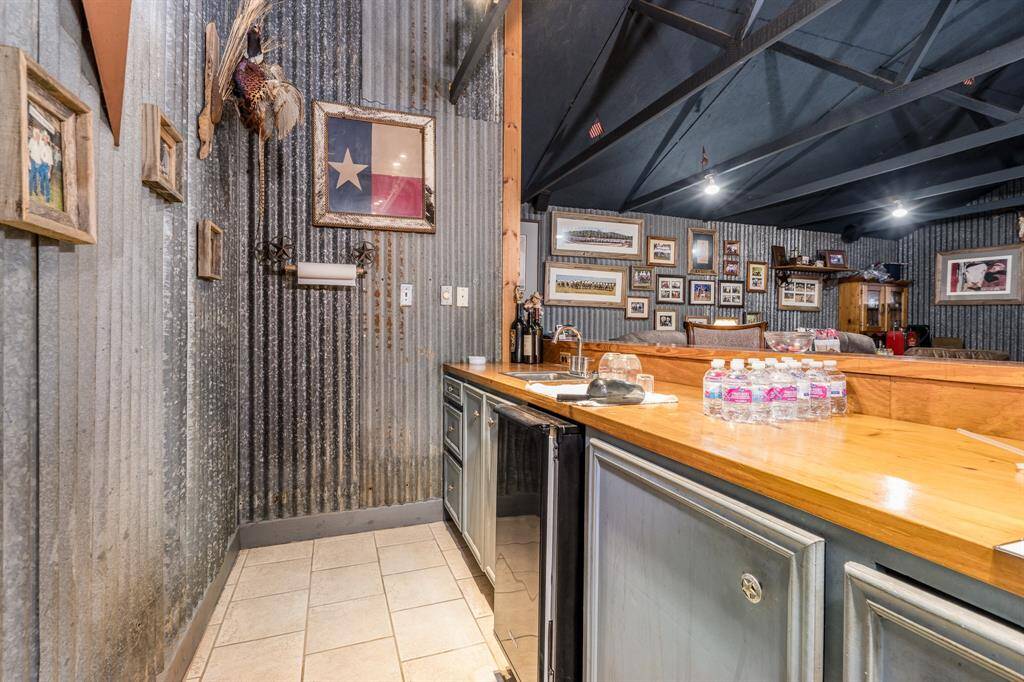 Bar includes a fridge and sink with wood counters.