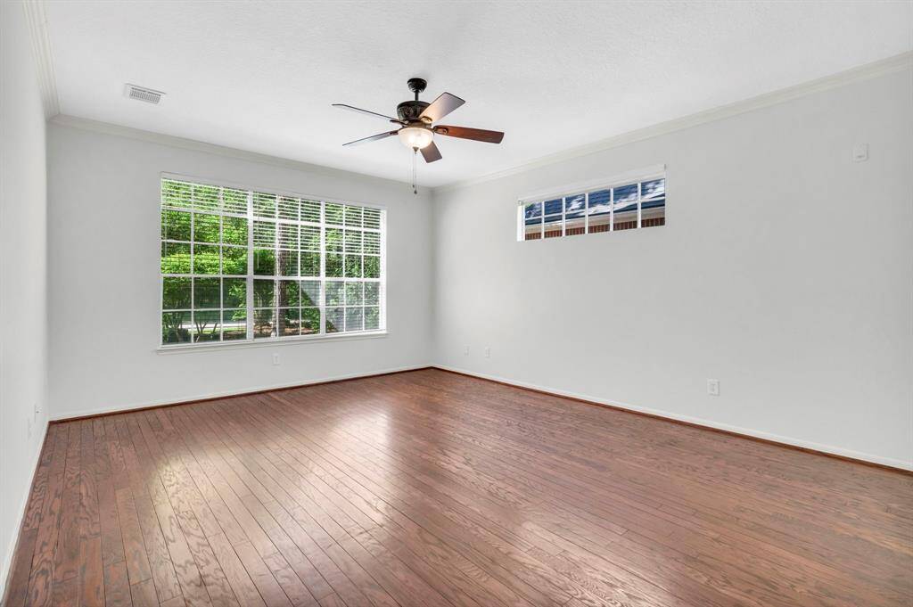 Primary bedroom on first floor with beautiful  views of neighborhood park directly in front of home