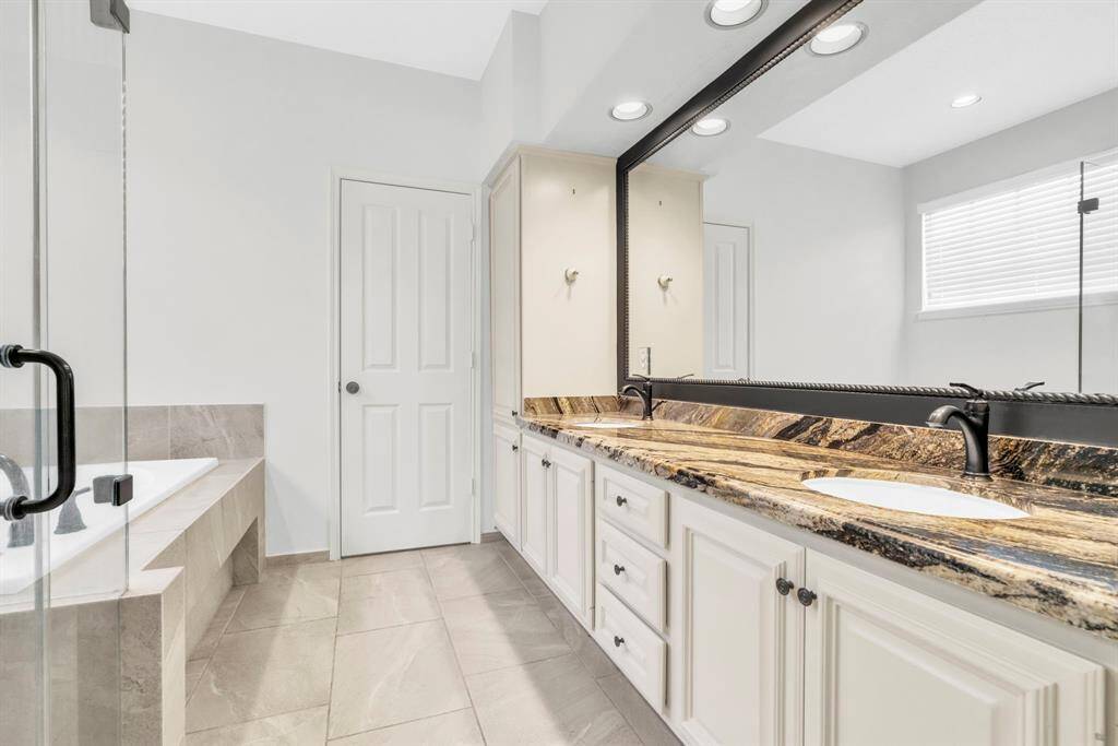Downstairs bath in primary bedroom.  Double sinks, jetted tub, glass-enclosled shower.