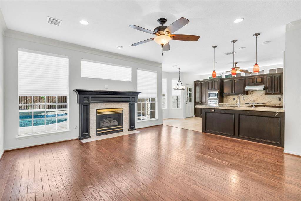 Another view of family room with fireplace and back windows overlooking pool