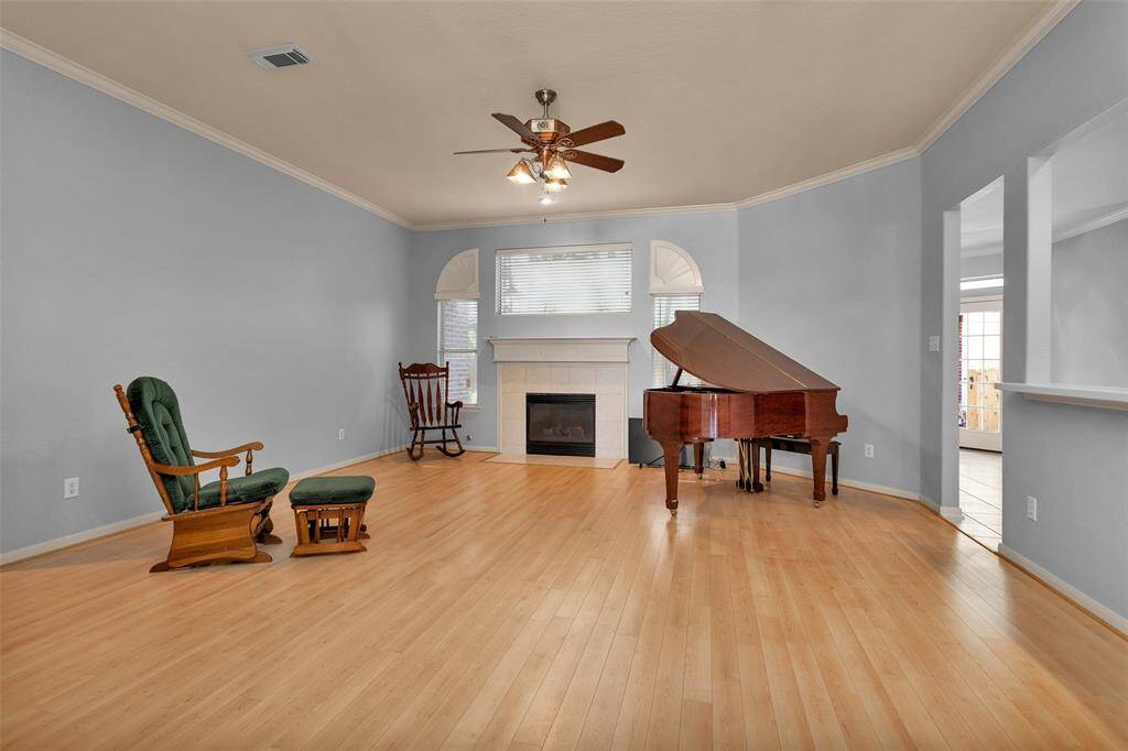 Experience elegance in this spacious living room featuring a cozy fireplace, abundant natural light, and beautiful hardwood floors. The perfect setting for relaxation and entertaining.