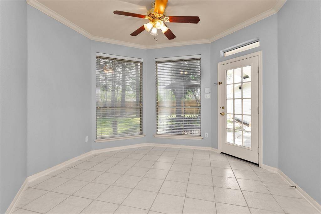 Spacious primary bedroom with elegant tray ceiling and light wood floors. Enjoy direct access to the luxurious bathroom, offering convenience and comfort.