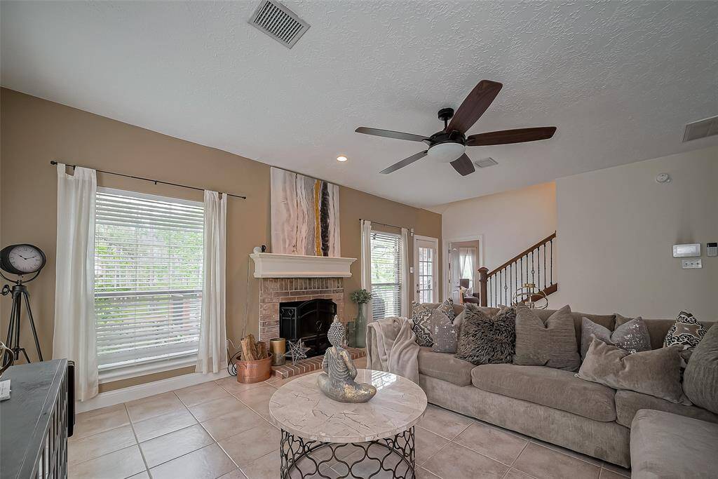 This inviting living room features a cozy fireplace and large windows with natural light