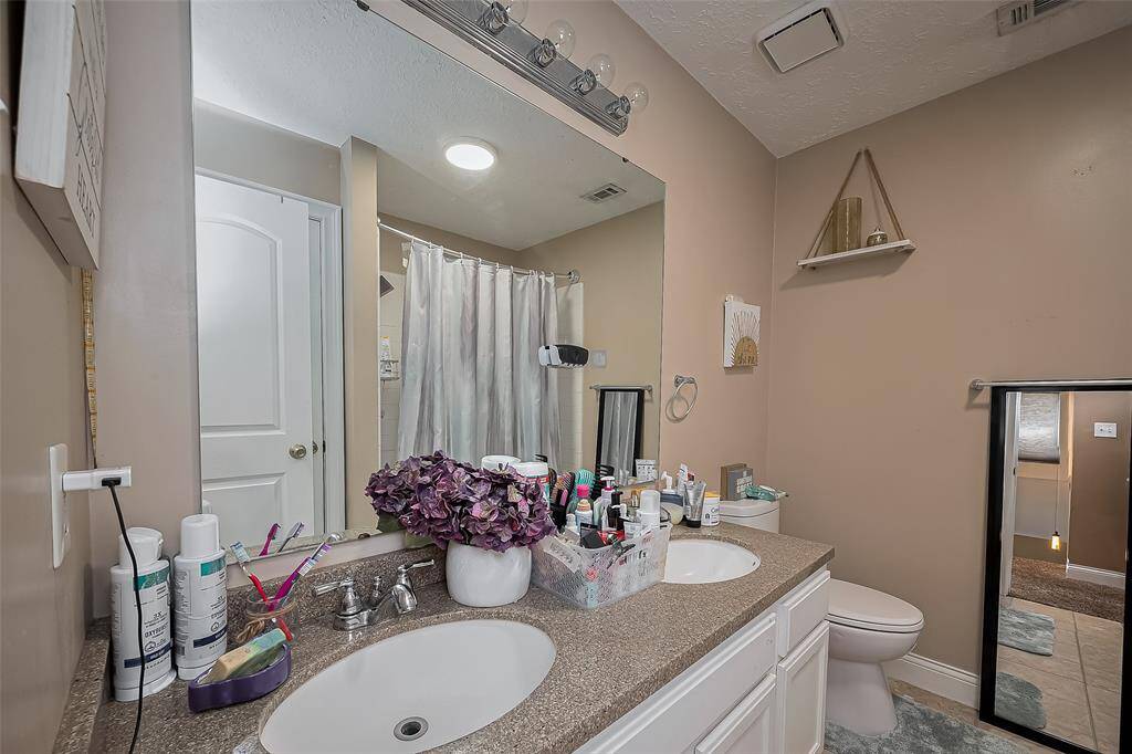 The bathroom features a double sink vanity with ample countertop space and storage.