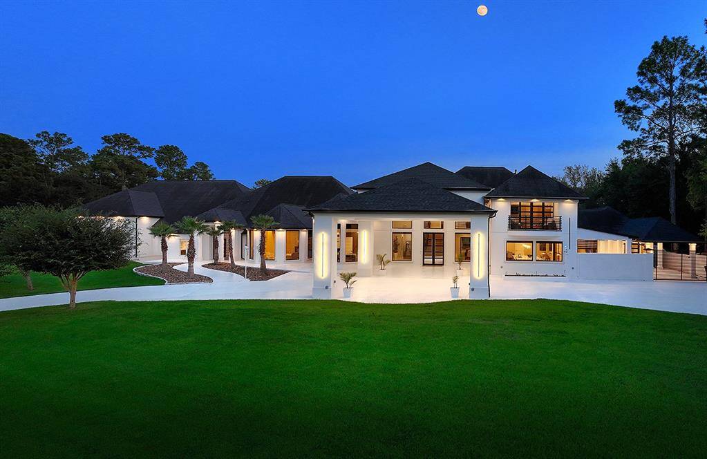 A stately porte-cochere welcomes you into this lavish contemporary home featuring East and West wings and an 18 car garage!