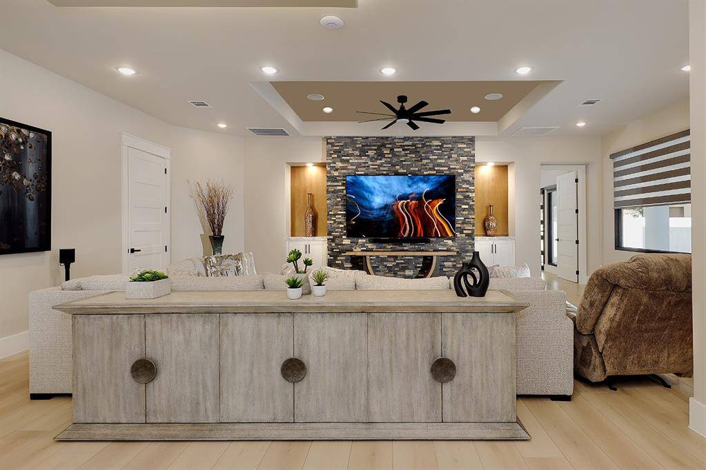 This casual living area off the kitchen provides a space for all to gather, with lighted art niches, custom built-in cabinetry and accent wall.