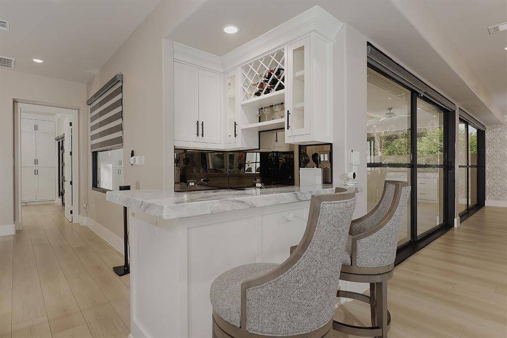 This convenient bar is located off the kitchen and formal dining, with quartzite counters, an ice maker and wine chiller.