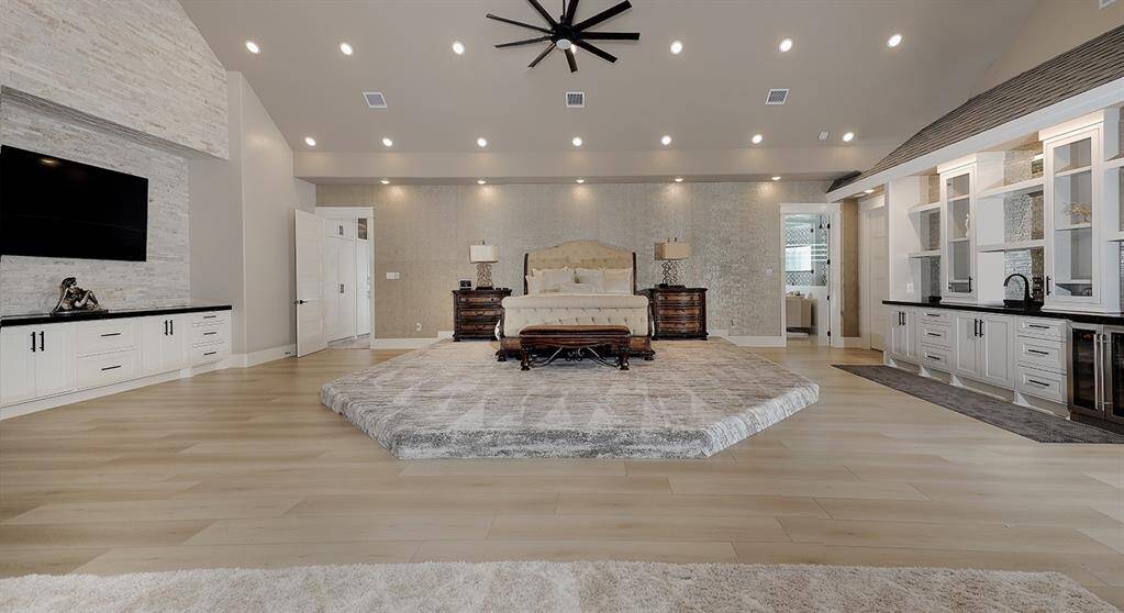 The massive owner's retreat downstairs exudes glamour, with silk and wool carpeted areas, a coffee bar with sink and fridge, and stunning accent wall.