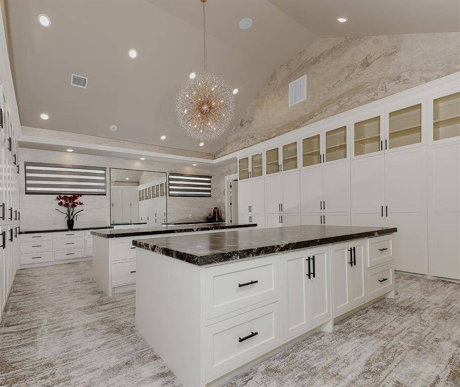 This closet in the owner's retreat is a work of art! The vaulted ceiling is centered by a sparkling chandelier, and dual islands with cabinet and drawer storage make packing a breeze!