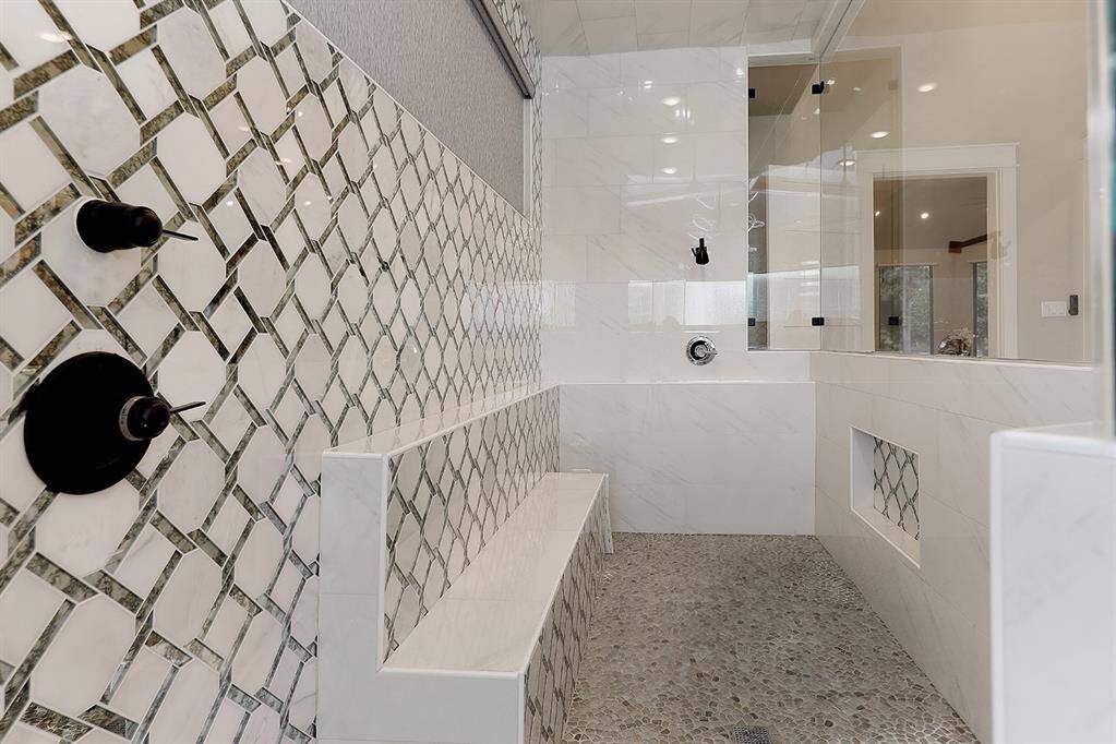 The enormous shower in the primary bath has a large bench and gorgeous tile.