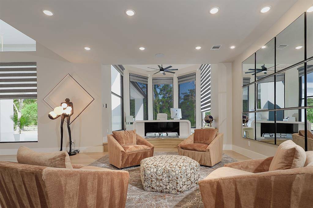 The formal living area seamlessly opens to the home office - notice the high baseboards and luxurious furnishings.