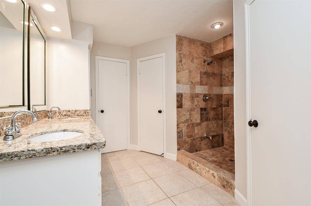 Primary bath with granite counters, dual sinks and updated fixtures.