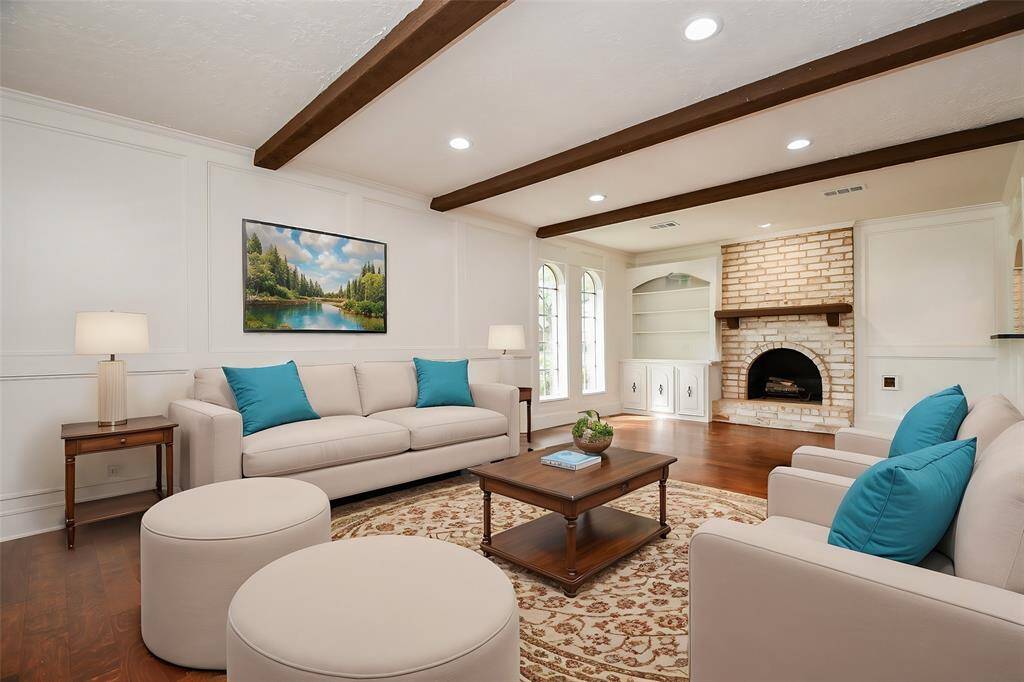 Welcome to this spacious living room with accent ceiling beams and a gas fireplace. (virtually staged)