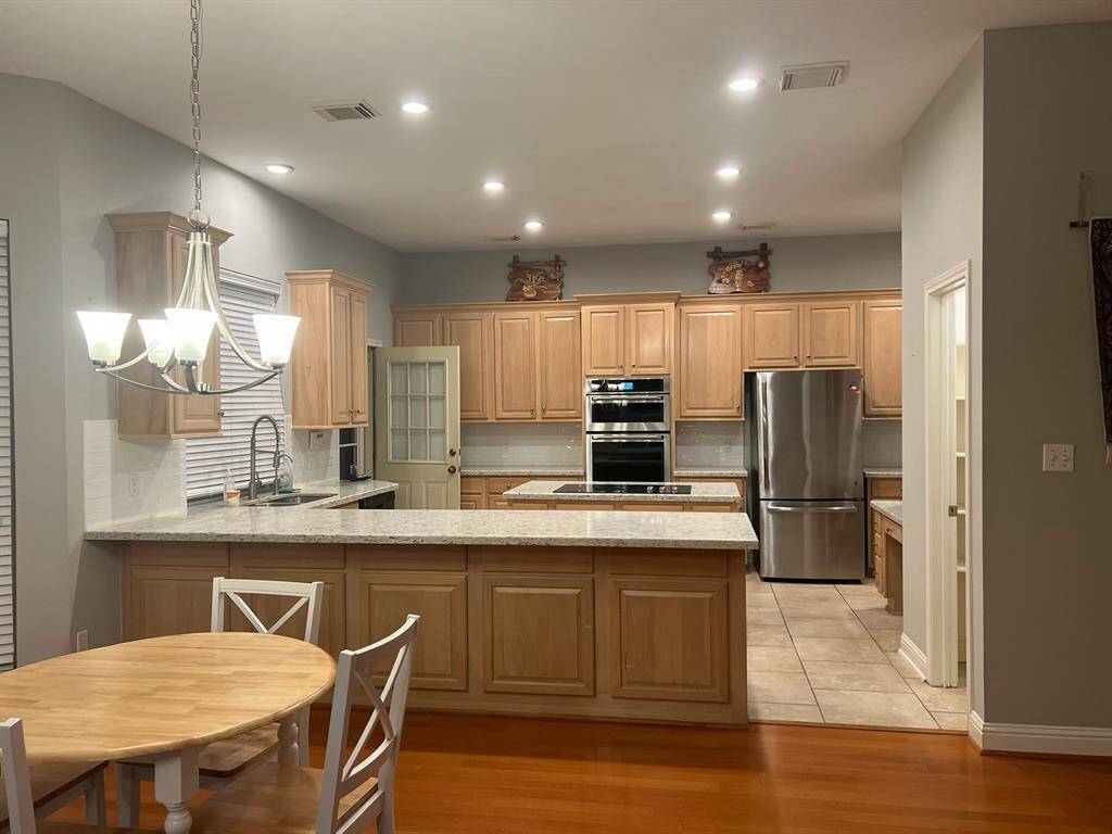 Kitchen with gorgeous granite countertops, breakfast bar, recent appliances and refrigerator provided