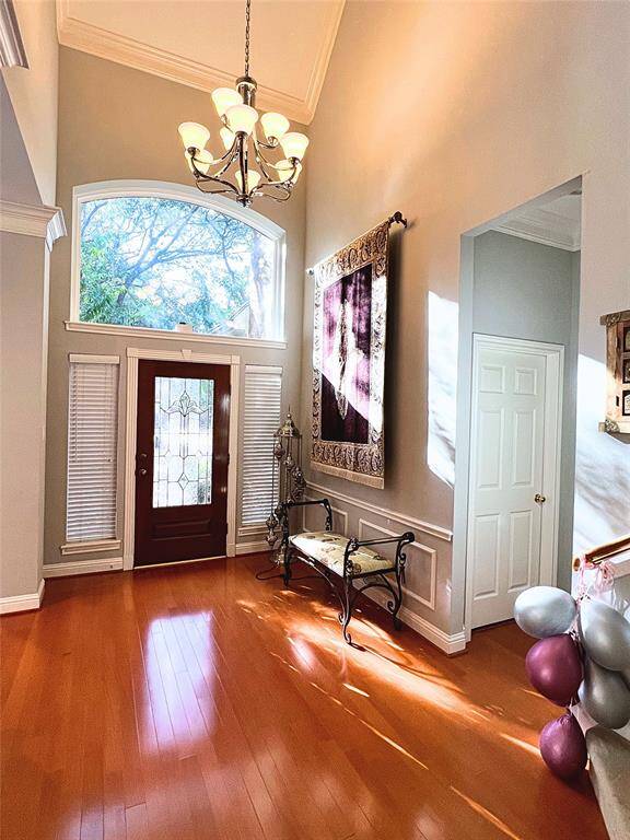 The formal dining room with elegant light fixture, open to the stairway, and access to the butler’s pantry and kitchen on the right
