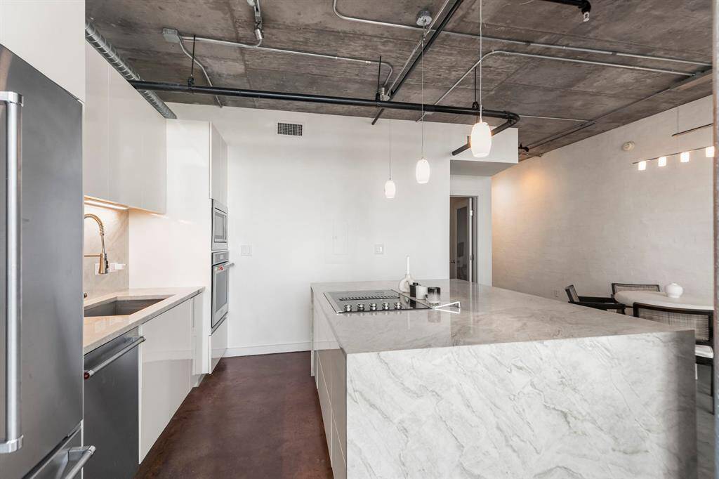 All cabinetry and drawers are touch-latch creating a sleek and clean look. Quartzite backsplash and under cabinet lighting.