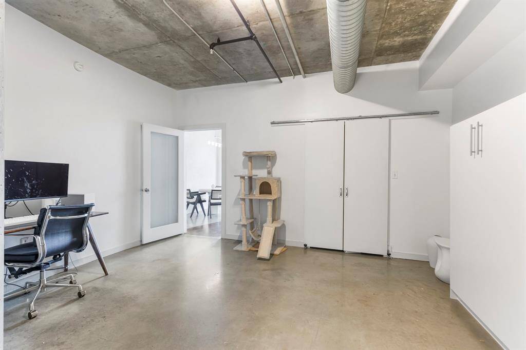 Large 1st floor bedroom has concrete flooring. Barn doors open to large closet.