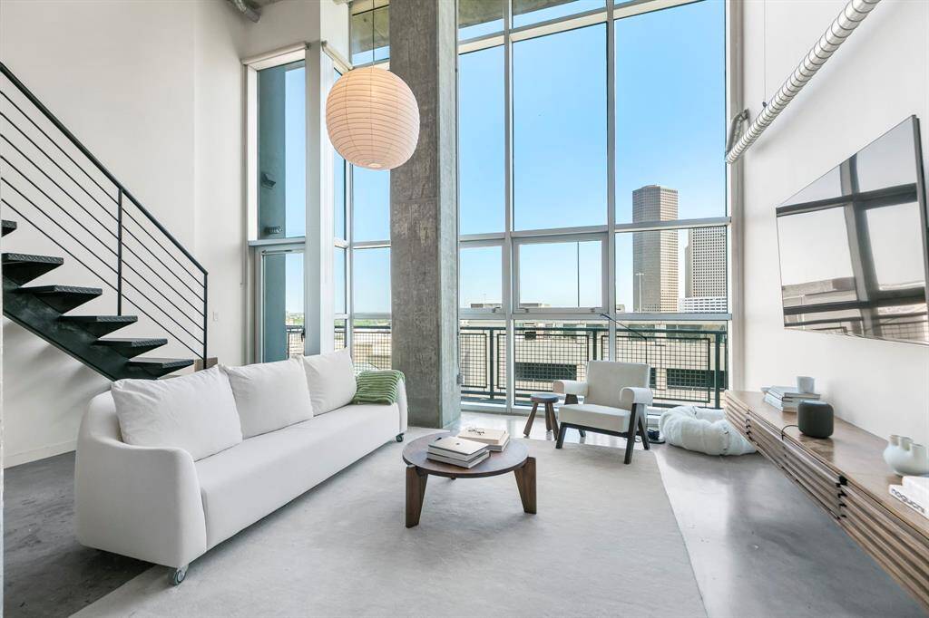 Spacious living area with a wall of windows and Downtown views! Door opens to your patio.