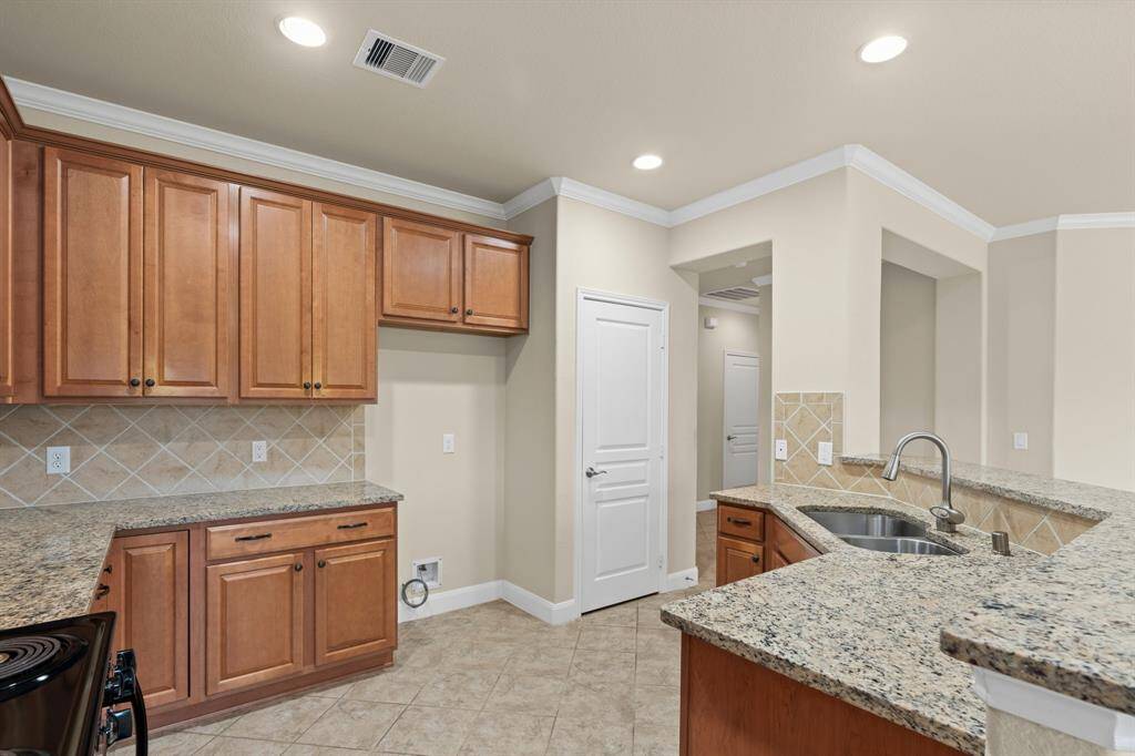 Beautifully upgraded cabinets bring warmth and charm to the kitchen, while crown molding adds a crisp, elegant contrast that really makes the space shine.