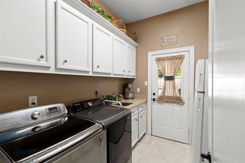 Nice Sized Laundry Room with Plenty of Shelving and Cabinets for Storage