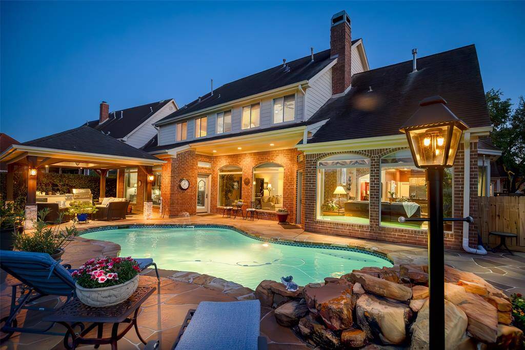Enormous Backyard with a Well-maintained Swimming Pool, Patio Area, and Covered Seating Space.