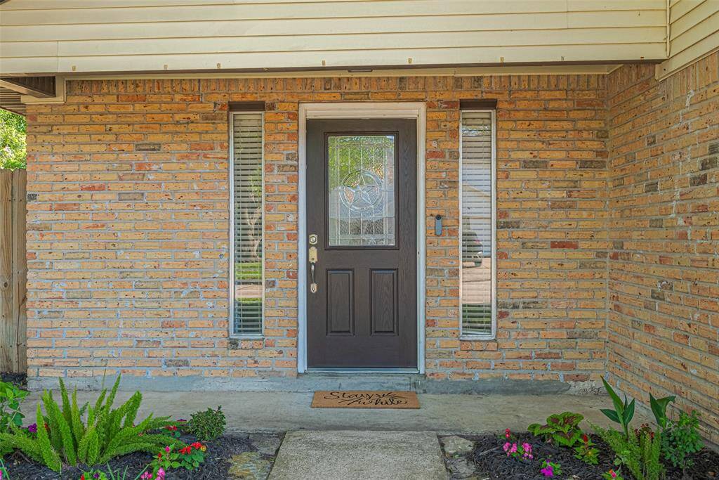 Front of home with new door. Fresh mulch and landscaping.