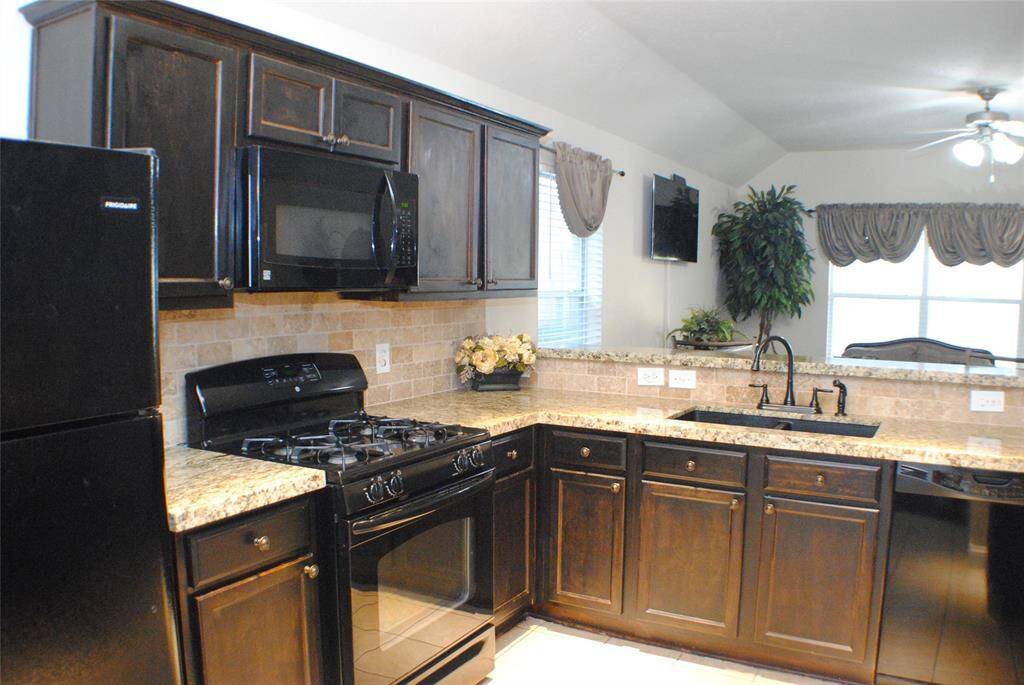 Look at this beautiful kitchen, featuring granite counters and black appliances