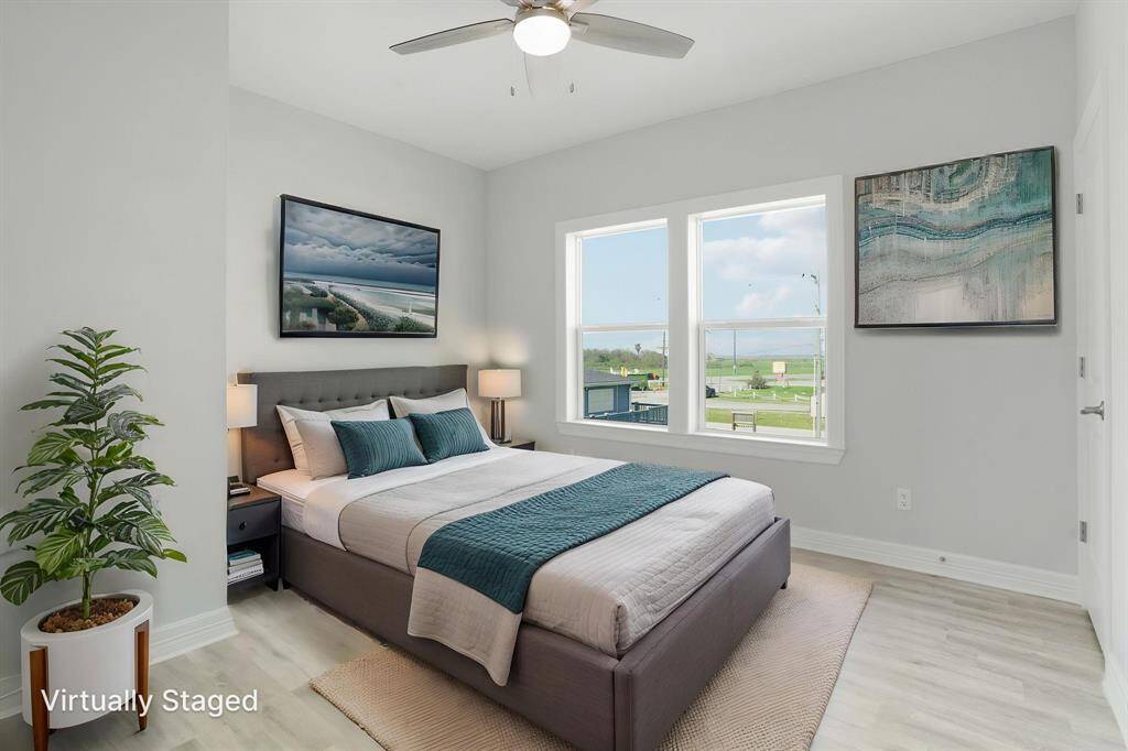 Inviting second bedroom featuring sleek flooring, ample natural light, and a modern ceiling fan for comfort.