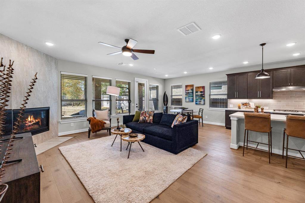 The main bedroom showcases a cozy yet spacious design with ample natural light from large windows. It includes room for comfortable seating and a neutral color palette, creating a relaxing atmosphere.