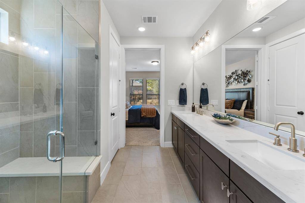 This photo showcases the main bedroom's spacious walk-in closet with ample hanging space and shelving. The carpeted floor and bright lighting create a clean, organized look.