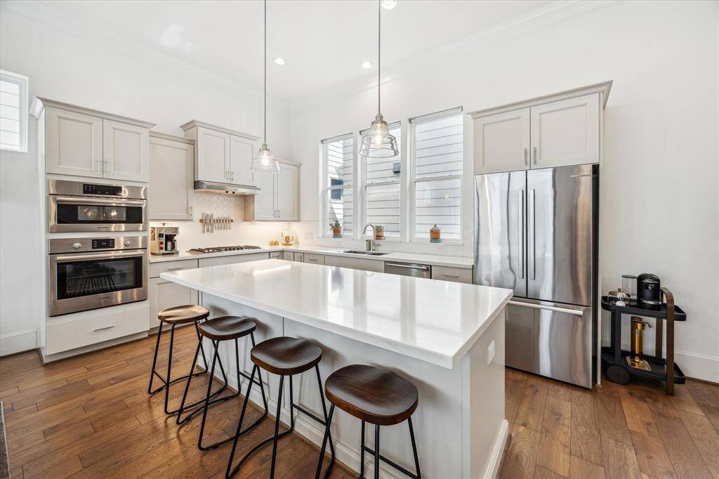 An oversized island serves as the centerpiece of this beautiful kitchen, offering ample workspace for meal prep and cleanup, along with convenient bar seating for casual conversations, quick snacks, and morning coffee.