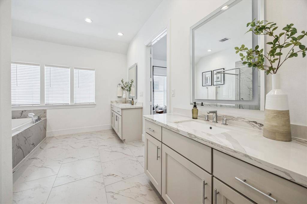 This luxurious ensuite has everything you need to prepare for the day ahead or unwind from the one just ending. With dual vanities, a soaking tub, and a separate walk-in shower, this serene space becomes your own private escape.