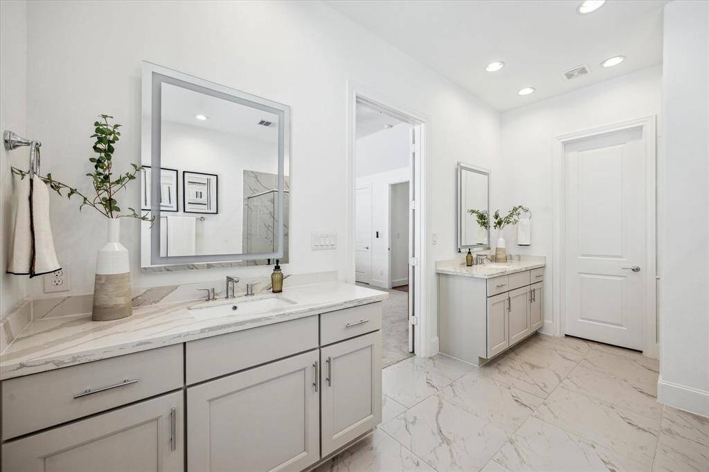 The owner's ensuite is designed for effortless sharing, featuring two separate vanities with ample storage below and framed mirrors above, combining style and function in a beautifully appointed space.