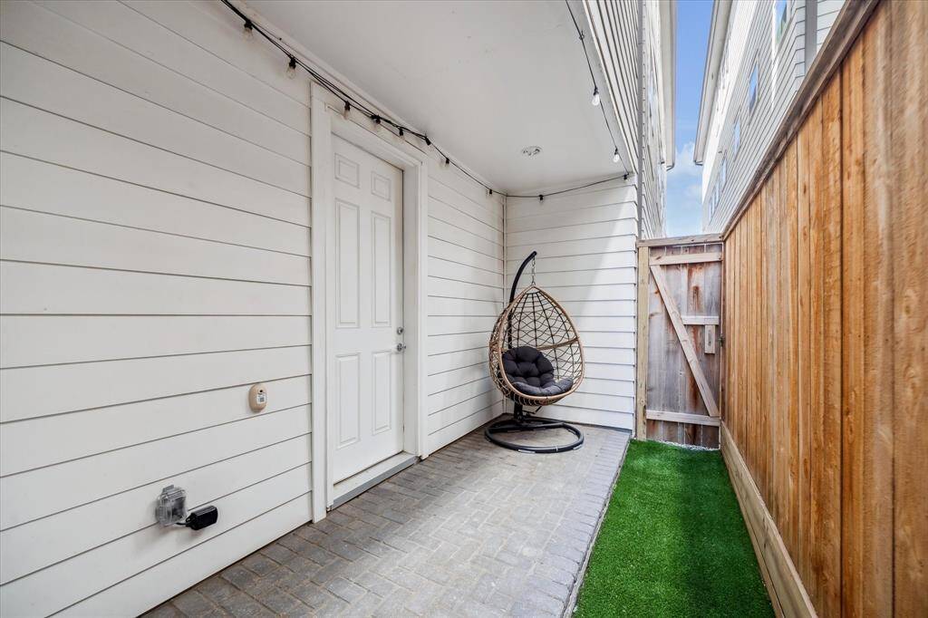 Step out to this private, covered patio just off the first-floor guest suite, a peaceful escape with space to sit back and relax, plus zero-maintenance artificial turf that keeps things looking fresh year-round.