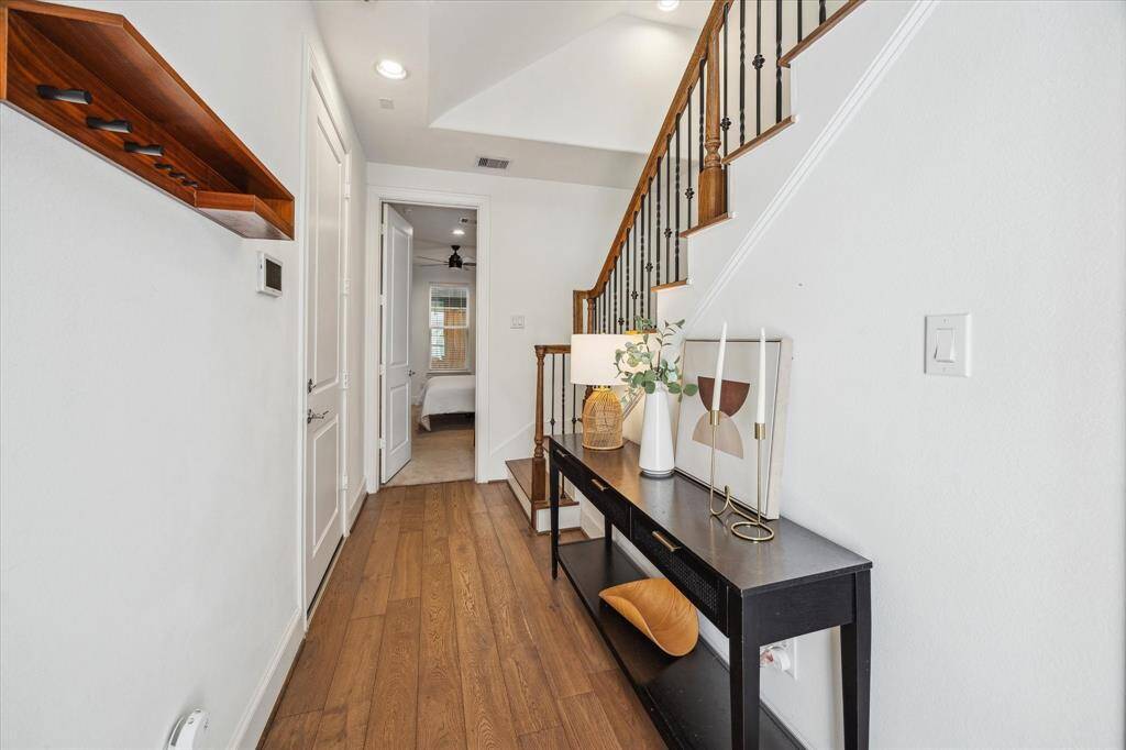 The 1st floor features an expansive entry with engineered wood flooring, neutral paint, and a stylish staircase with wood railings and ornate iron spindles. You’ll also find a spacious guest suite with a large closet and private ensuite bathroom.