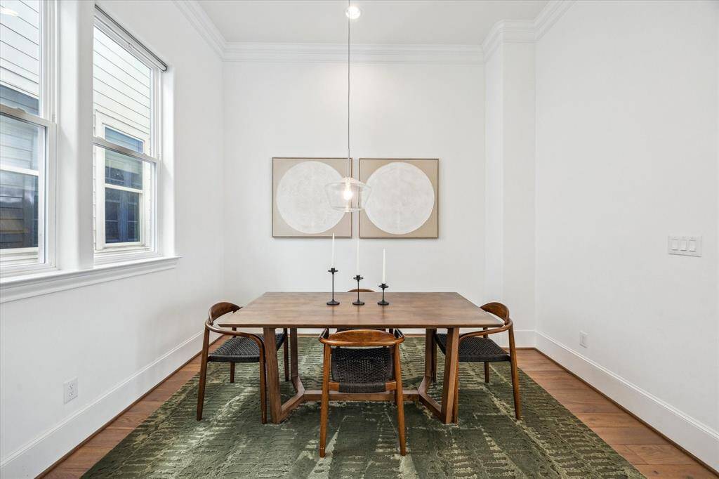 You may be inspired to entertain more often with the help of this elegant dining room, featuring chic lighting, neutral paint, and ample space for your dining table and sideboard.