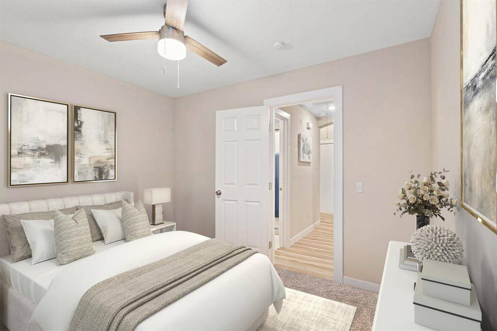 Another view of the bedroom featuring plush carpet, a large window for natural light, and a sleek modern ceiling fan for added comfort. *Virtually Staged*