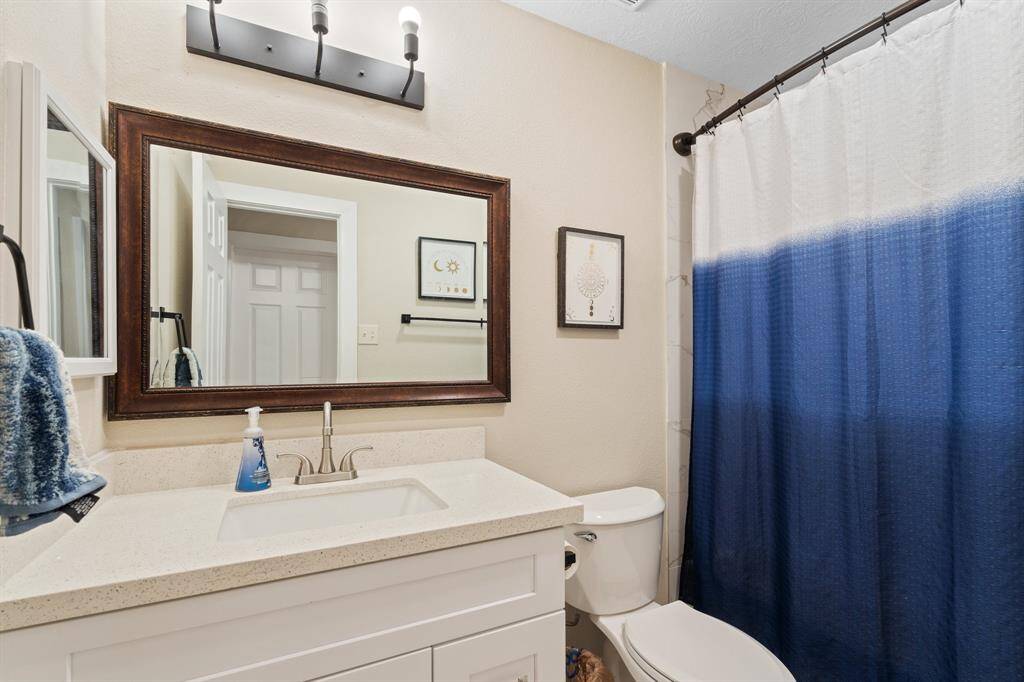 This stylish bathroom features a modern sink vanity, a sleek toilet, and a convenient shower/tub combo, offering both functionality and comfort.