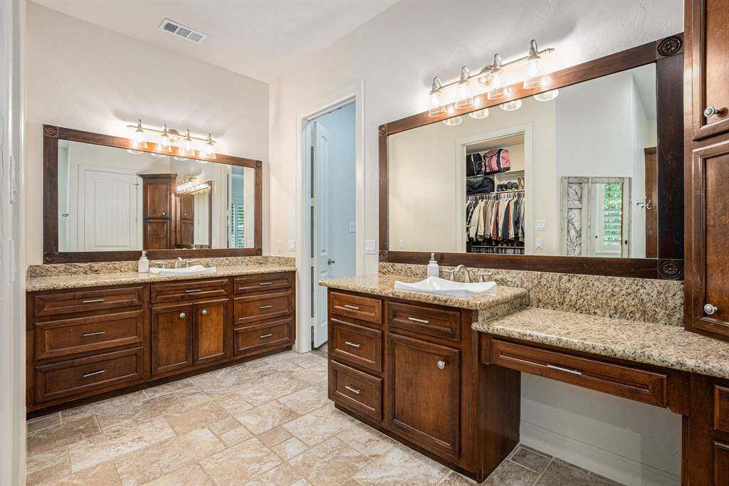 Lavish primary en suite includes dual vanities, lots of countertop and storage space, and a massive walk-in closet.