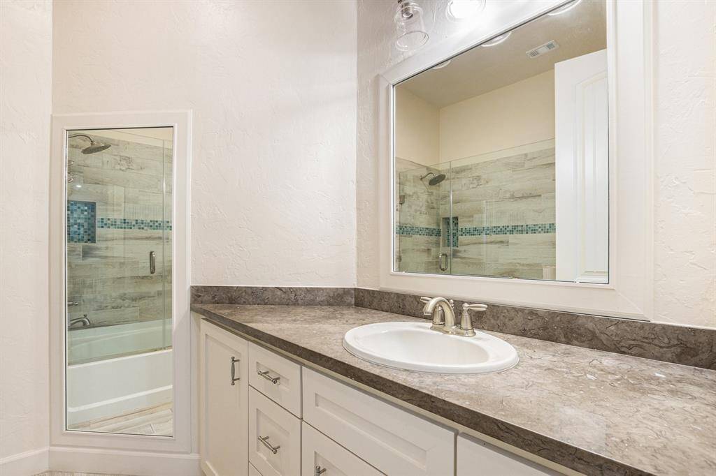 Full private bathroom offers a combination tub and shower and tons of storage and countertop space.